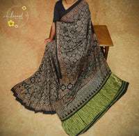 APL2026 Black Modal Silk saree featuring all-over Ajrakh block prints with Geometric Medallions and Olive-Green border.