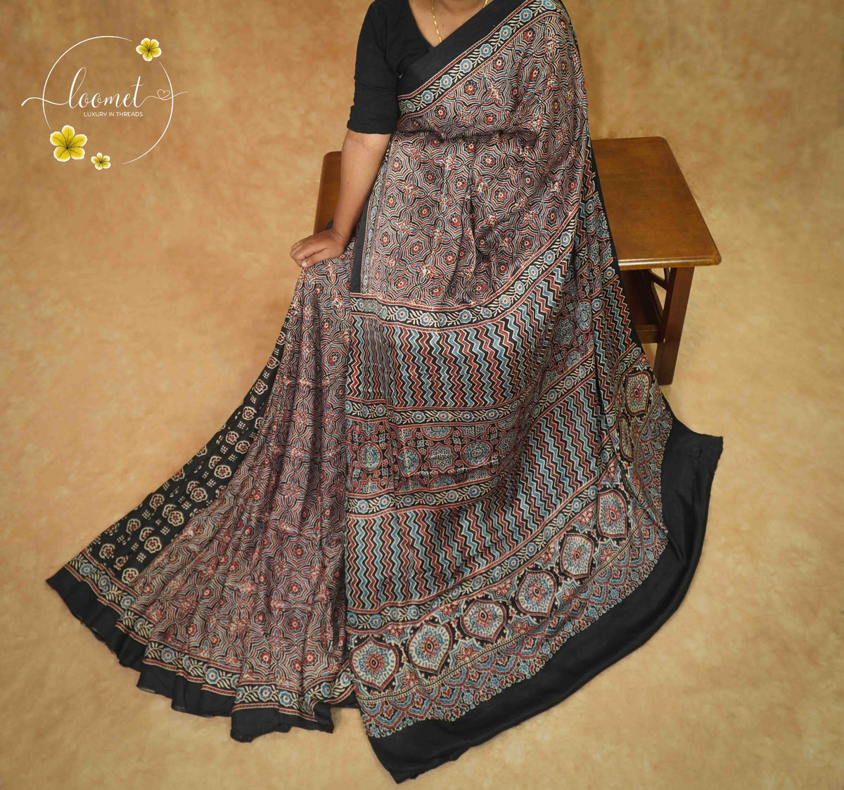 APL4121 Black Modal Silk saree featuring all-over Ajrakh block prints with Geometric Chevrons and floral medallions.