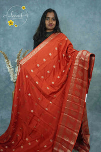 ARN3408 Deep Orange-Red Mysore Silk saree features floral buttas with zari paisley borders.