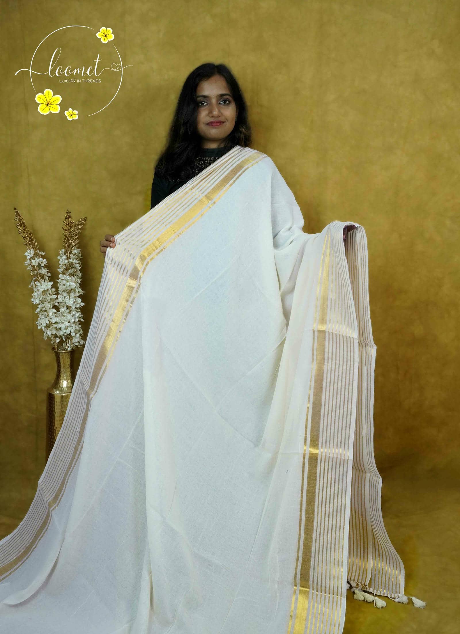 ASB25636 White saree with a minimalist design featuring a broad vertical panel with gold zari stripes by matching tassels.