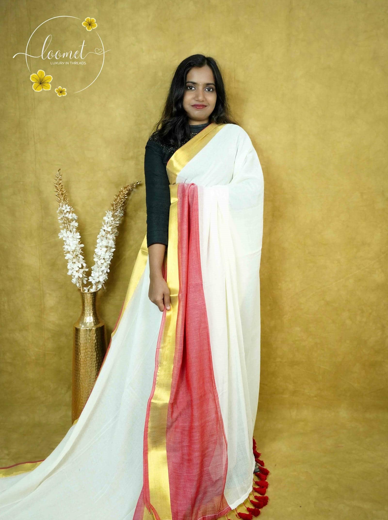 ASB25640 White and light pink colour saree with a textured body featuring a broad vertical stripe of Gold Zari with Matching Tassels.