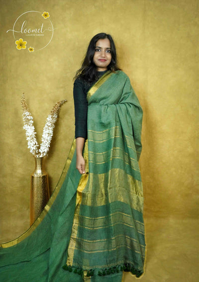ASB2566 Moss green saree with textured body featuring fine horizontal antique gold stripes with vertical gold zari border and contrasting teal green tassels.