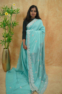 IWS4111 Aqua Blue Tissue Organza saree with silver sequin  buttas shaped like small leaves.