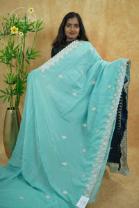 IWS4111 Aqua Blue Tissue Organza saree with silver sequin  buttas shaped like small leaves.
