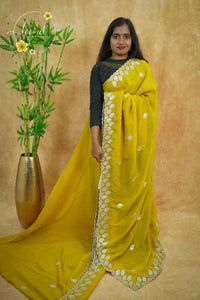 IWS4112 Yellow Tissue Organza saree with silver sequin buttas shaped like small leaves.