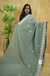 IWS4113 Sage Green Tissue Organza saree with silver sequin buttas shaped like small leaves.