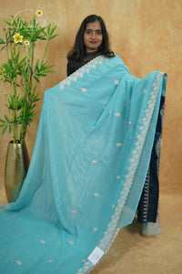 IWS4115 Sky Blue Tissue Organza saree with silver sequin buttas shaped like small leaves.
