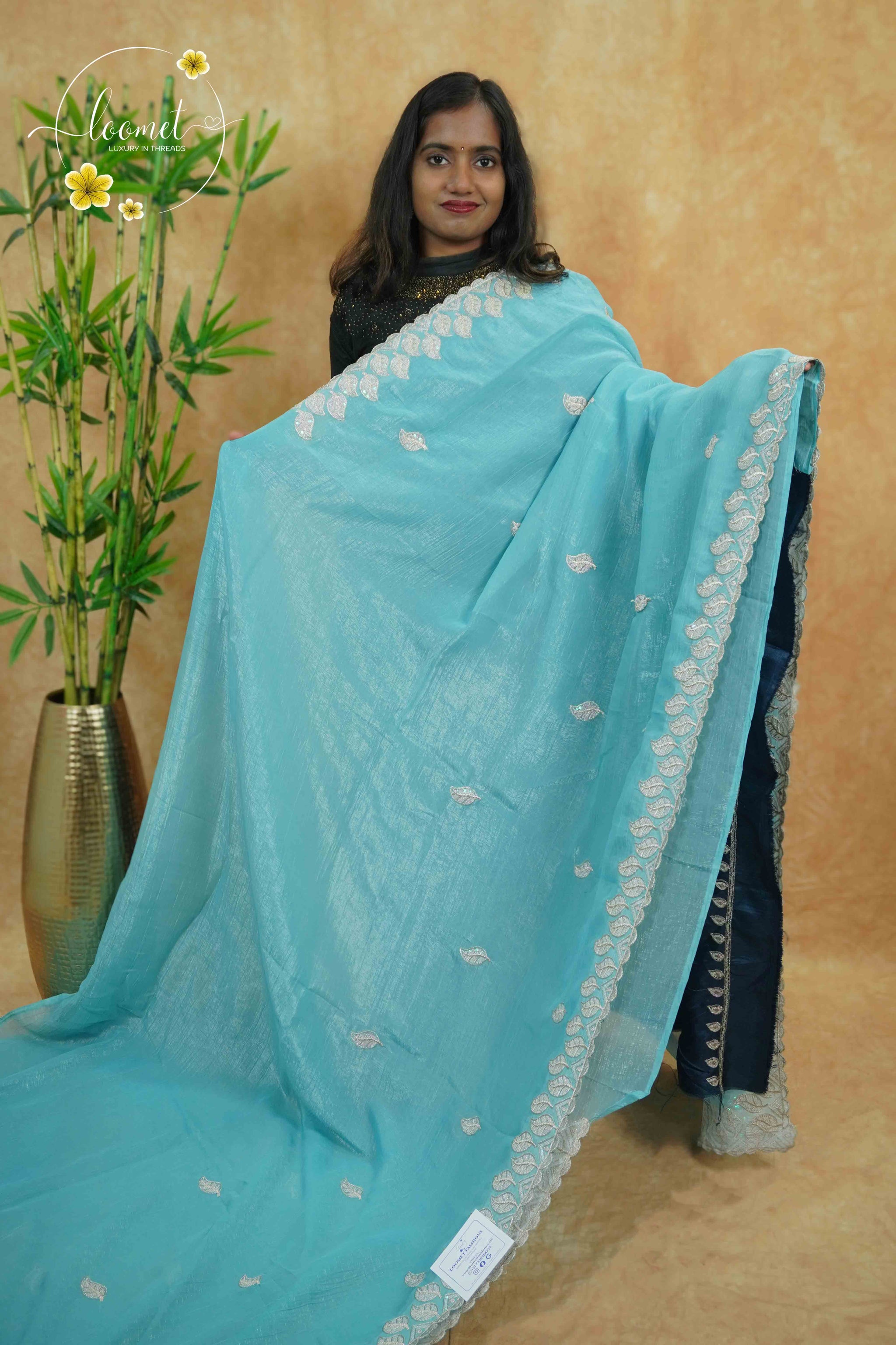 IWS4115 Sky Blue Tissue Organza saree with silver sequin buttas shaped like small leaves.