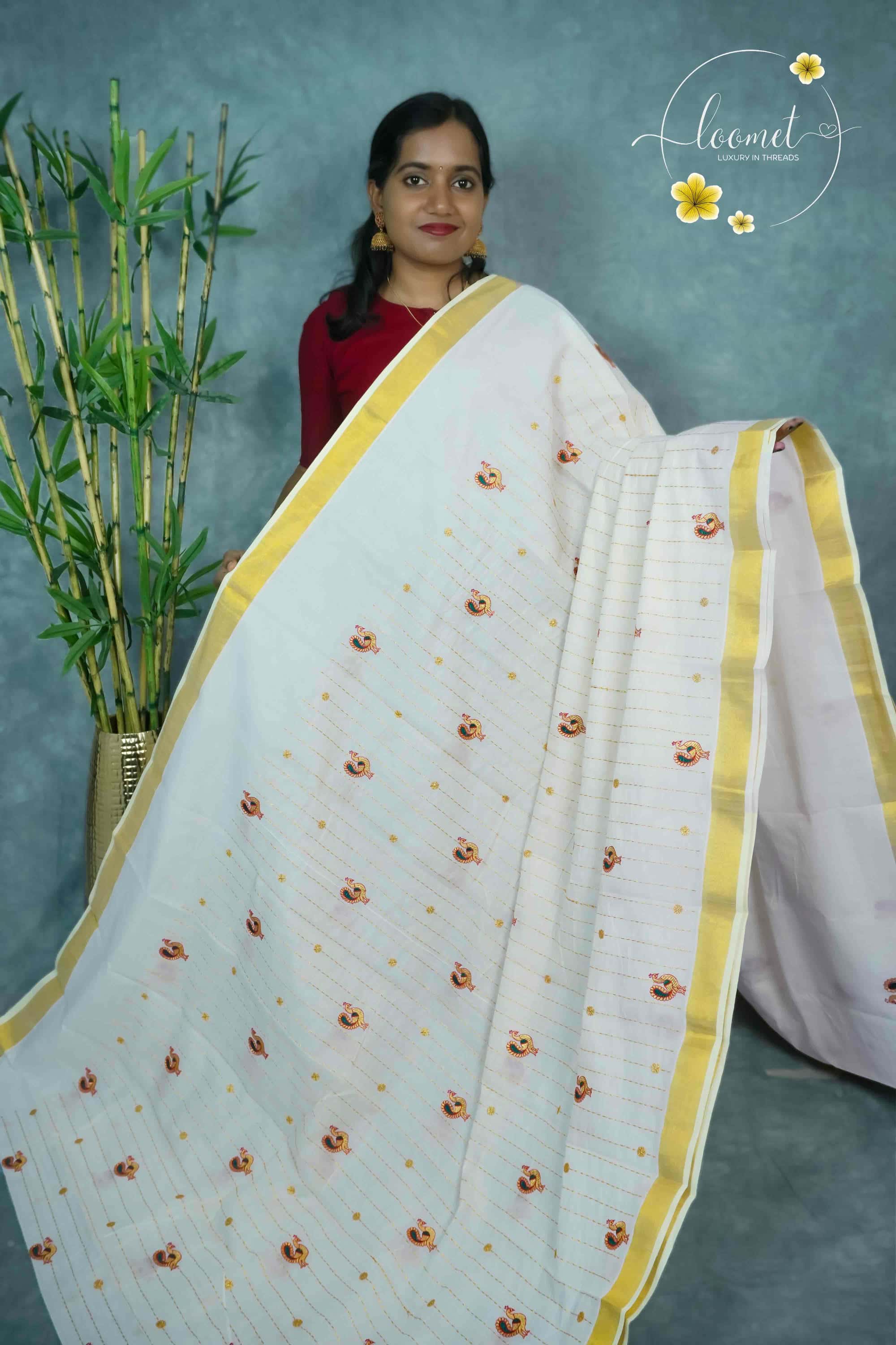 MKF3270 White saree features a golden zari border and horizontal lines adorned with small peacock and floral embroidery.