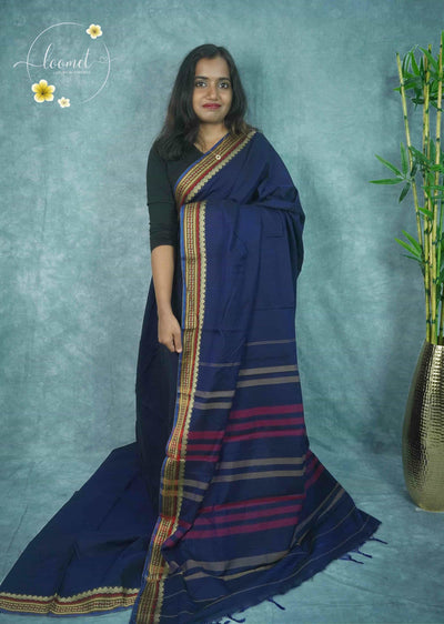 NLS1123 Navy blue saree features a solid body and a multi-toned border with golden geometric and leaf motifs.