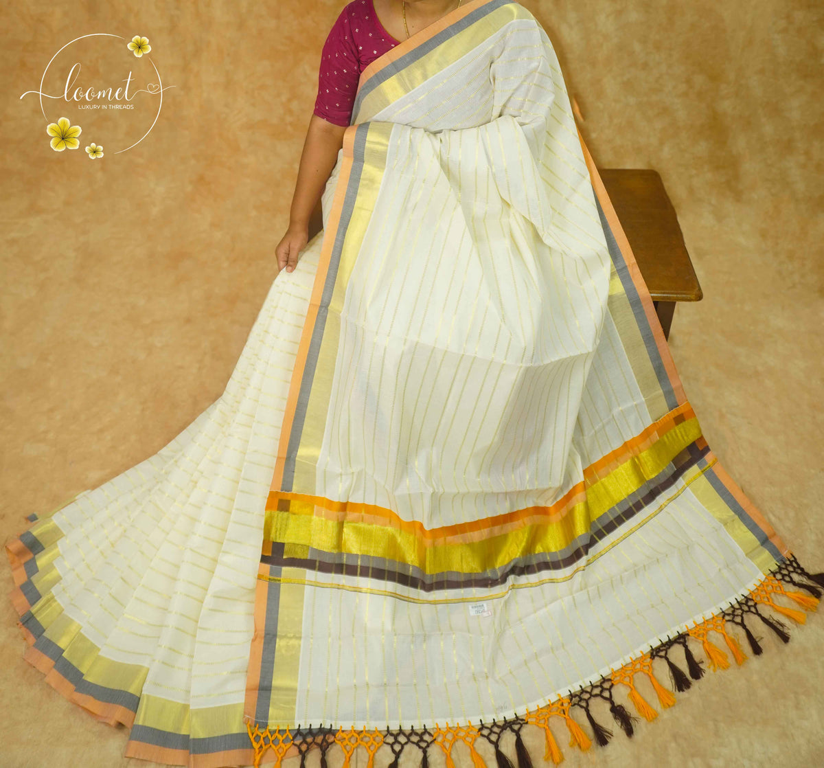 RKT2141 Off-White Kerala Cotton saree with Elegant Zari Pinstripes, Multi-Hued Borders, and Handcrafted Tassels.