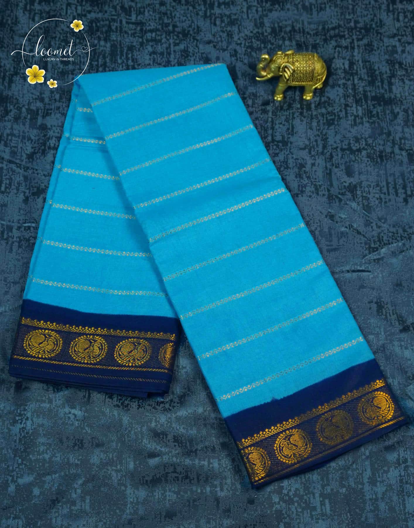 SPT3143 Sky blue saree with horizontal gold zari stripes on the body with antique gold brocade peacock motifs on a solid navy blue base.