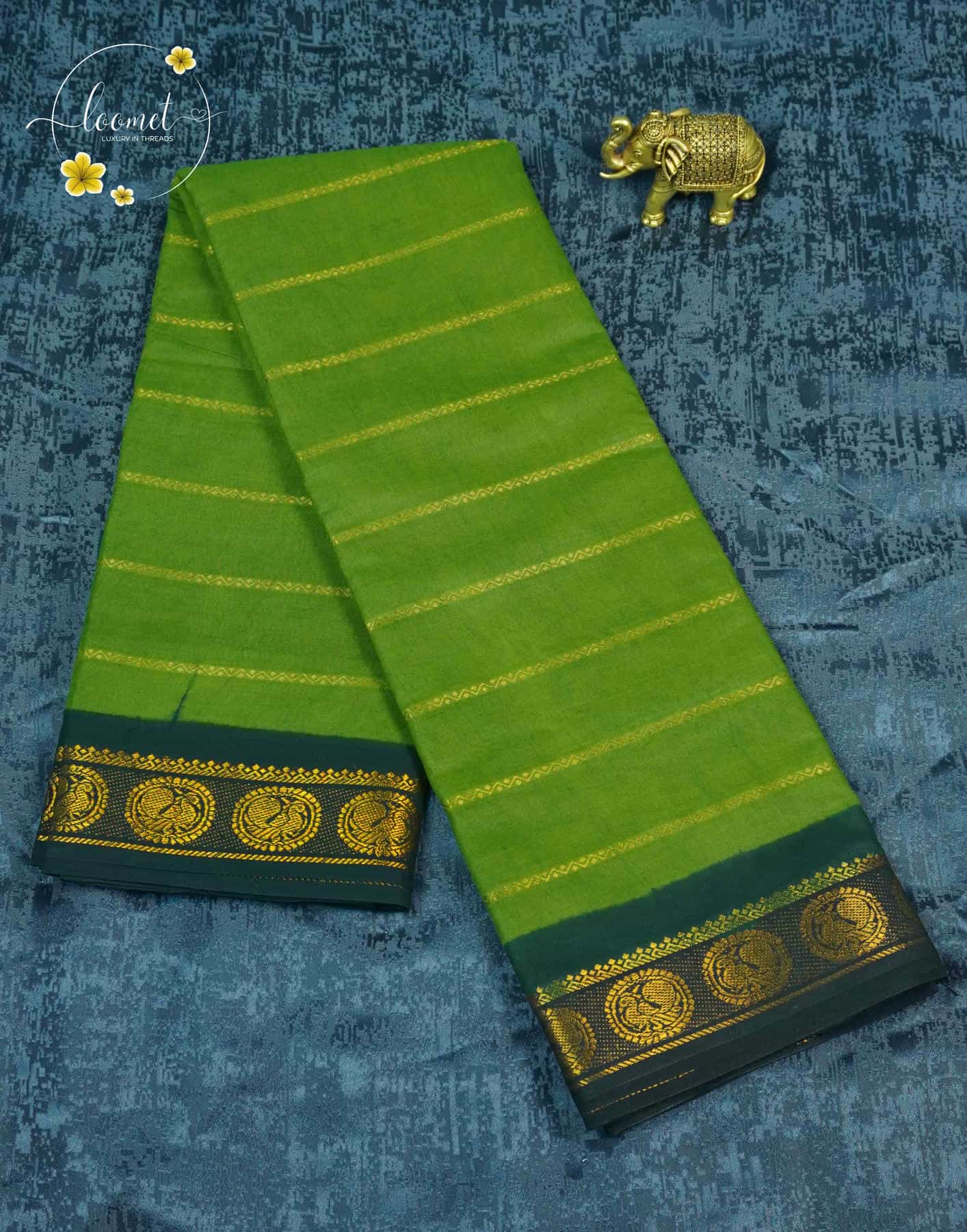SPT3144 Grass green saree with horizontal gold zari stripes on the body with gold brocade peacock motifs on a solid black base.